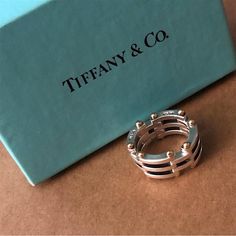 This Elegant And Timeless Gate Link Ring In Fine Sterling Silver With 18k Gold Makes A Worthy Addition To Any Jewelry Collection. Made By Tiffany & Co., Its Flawless Craftsmanship And Design Perfection Features A Collapsible Gate Link Design. The Artfully Design Gold Hinge Details Yet Amplify Its Incredibly Detail Precision. Details Type: Ring Design: Gate Link Size: 5.5 Metals: Sterling Silver/18k Gold Total Weight: 11.5g Marks: Tiffany & Co. 925 750 Condition: Pre-Owned/Good Collapsible Gate, Tiffany Atlas Ring, Link Ring, Link Design, Linking Rings, 18k Yellow Gold Ring, Yellow Gold Ring, Womens Jewelry Rings, Tiffany & Co.