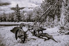 an old plow sitting in the middle of a field