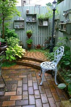 a small garden with a bench and potted plants