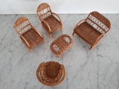 four wicker chairs and two tables on a marble surface