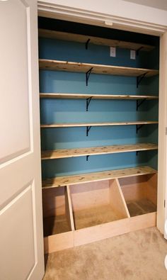 an empty walk in closet with blue walls and shelving units on the bottom shelf