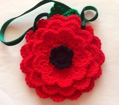 a crocheted red flower on a green strap