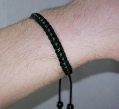 Black braided bracelet with a green line, this bracelet is adjustable to fit wrist sizes from 6 to 9 inches, with an easy to use zip like function to fit your wrist, you'll have it on as soon as you get it. Made from high quality string, it will be sure to last. Each bracelet is carefully handcrafted and give proper time to ensure quality. Fast and Free shipping Casual Resizable Wristband As Gift, Green Beaded Bracelets With Adjustable Cord For Friendship, Adjustable Green Friendship Bracelets, Gift Jewelry With Adjustable Paracord Cord, Gift Jewelry With Adjustable Paracord, Green Resizable Friendship Bracelet, Green Beaded Bracelets With Adjustable Length, Adjustable Green Beaded Bracelets With Sliding Knot, Adjustable Black Paracord Jewelry