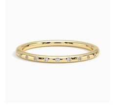 a yellow gold ring with small diamonds on the inside and outside, set against a white background