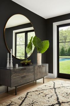 a living room with black walls and a large mirror