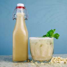 a bottle of milk next to a glass filled with drink