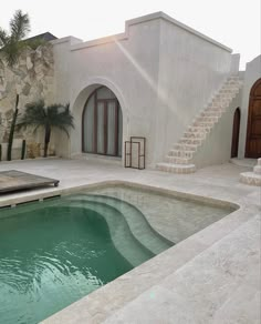 an instagramted photo of a house with a pool in the foreground and stairs leading up to it