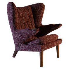 an upholstered purple chair with wooden legs