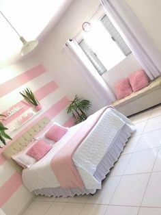 a bedroom with pink and white stripes on the walls, flooring and bedding