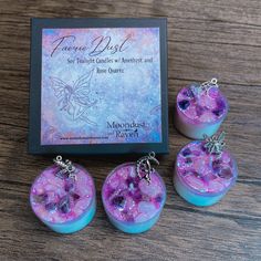 three purple and blue jewelry pieces sitting on top of a wooden table next to a card