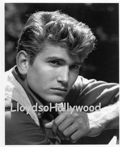 an old black and white photo of a man with his hand on his chin,