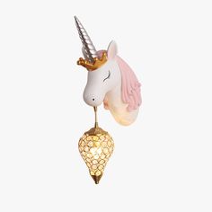 a white and pink unicorn head hanging from a light fixture with a gold chain around it's neck