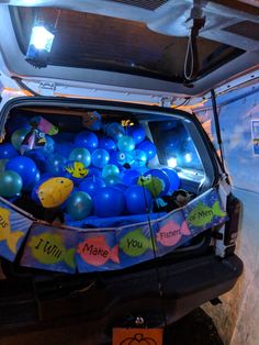 the back end of a car with balloons in it