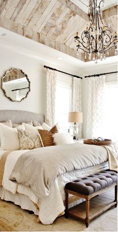 a bedroom with a large bed and a chandelier hanging from it's ceiling