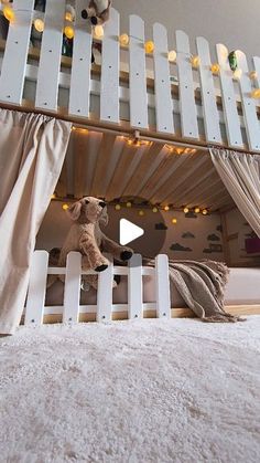 a teddy bear sitting on top of a white bunk bed