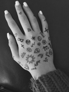 a person's hand with tattoos on it and other things drawn on the palm