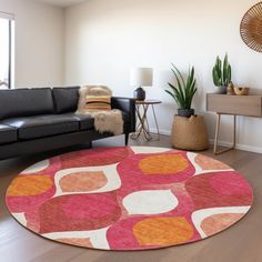 a living room with black couches and a pink rug