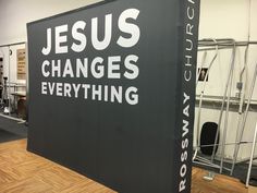 a large sign that says jesus changes everything in white letters on black and grey background