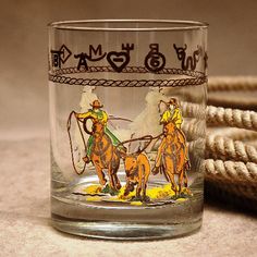 a shot glass with an image of two men on horses