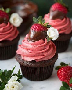 chocolate cupcakes with strawberry frosting and fresh strawberries on the top one