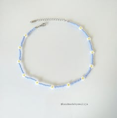 a blue and yellow beaded necklace on a white surface