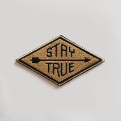 a stay true sign is shown on a white surface with an arrow pointing to the right