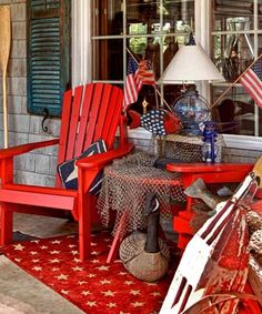 a red chair sitting on top of a red rug next to a table with an umbrella