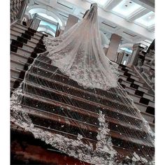 a wedding dress hanging from the side of a stair case in an ornately decorated building