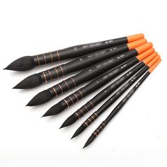 six black and orange paint brushes lined up in a row