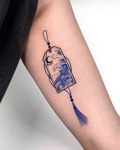 a woman's arm with a tattoo on it that has an image of the great wave