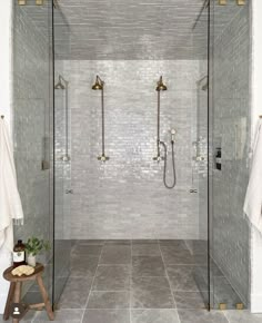 a walk in shower sitting next to a tiled wall