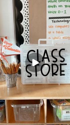 a classroom desk with clear plastic containers and writing on the sign that says class stop