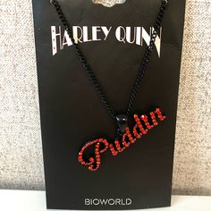 a black necklace with red beads and the word harley on it in front of a box