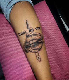 a woman's arm with a tattoo on it that says, trust no one