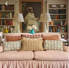 a living room filled with lots of furniture and bookshelves next to a painting