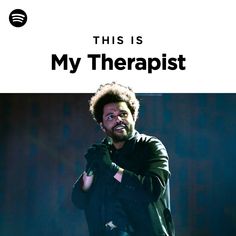 a man with an afro standing in front of a microphone and holding his hands out