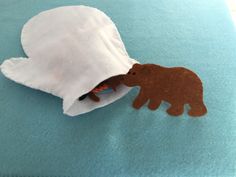 a paper bag with a brown bear sticking out of it on top of a blue rug