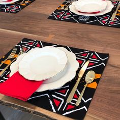 the placemats are decorated with red, yellow and black designs on them as well as silverware