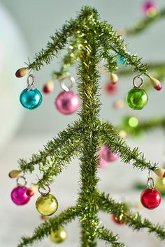 a small christmas tree with ornaments hanging from it