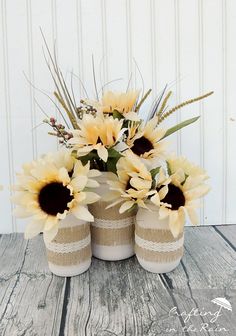 two vases with sunflowers are sitting on a table