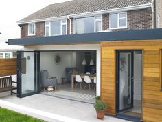 an outdoor living area with sliding glass doors on the outside and wooden furniture in the inside