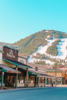 a town with mountains in the background and snow on the top of the mountain behind it