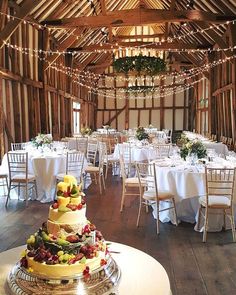 a wedding cake sitting on top of a table in a room filled with tables and chairs