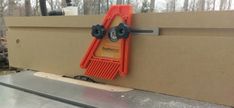 an orange tool is attached to the side of a cardboard box