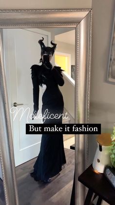 a woman in a black dress standing in front of a mirror with the caption, but make it fashion