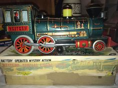 a toy train is sitting on top of a box with other toys in the background