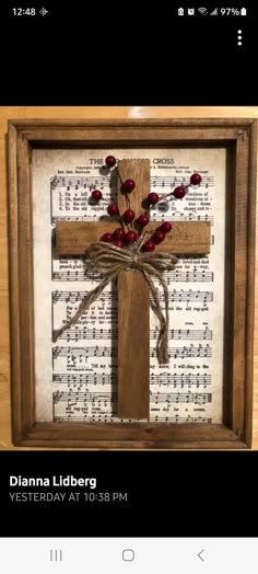 a wooden cross with flowers on it and sheet music in the background, as well as an mp3 player