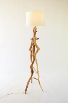 a lamp made out of branches with a white shade on the top and bottom side