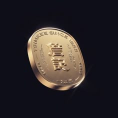 a gold coin with chinese writing on the front and side, against a black background