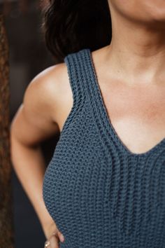 a close up of a person wearing a tank top with her hands on her hips